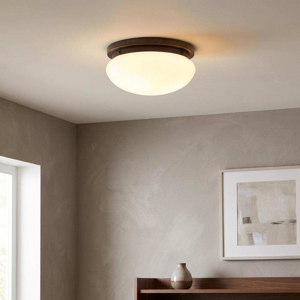 Illuminated Art Deco white glass bowl flush ceiling light with dark bronze trim in a neutral modern interior.