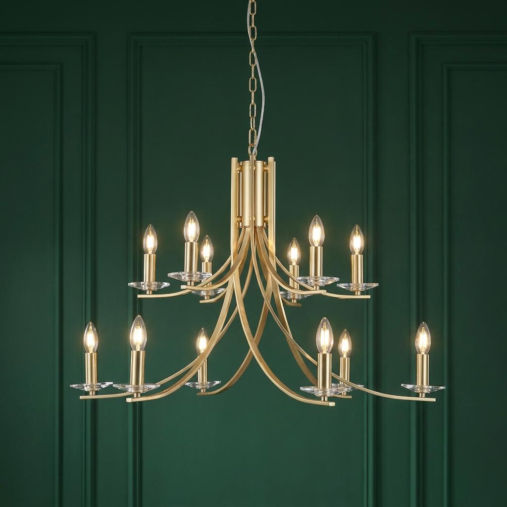 A two-tier satin brass Ascona chandelier with twelve candle bulbs set against a dark green paneled wall.