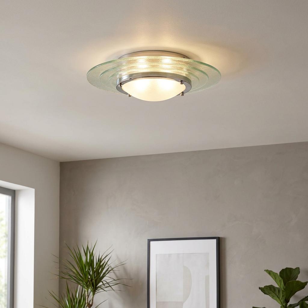 Modern Art Deco chrome flush ceiling light with concentric glass rings, glowing above a neutral-toned room.