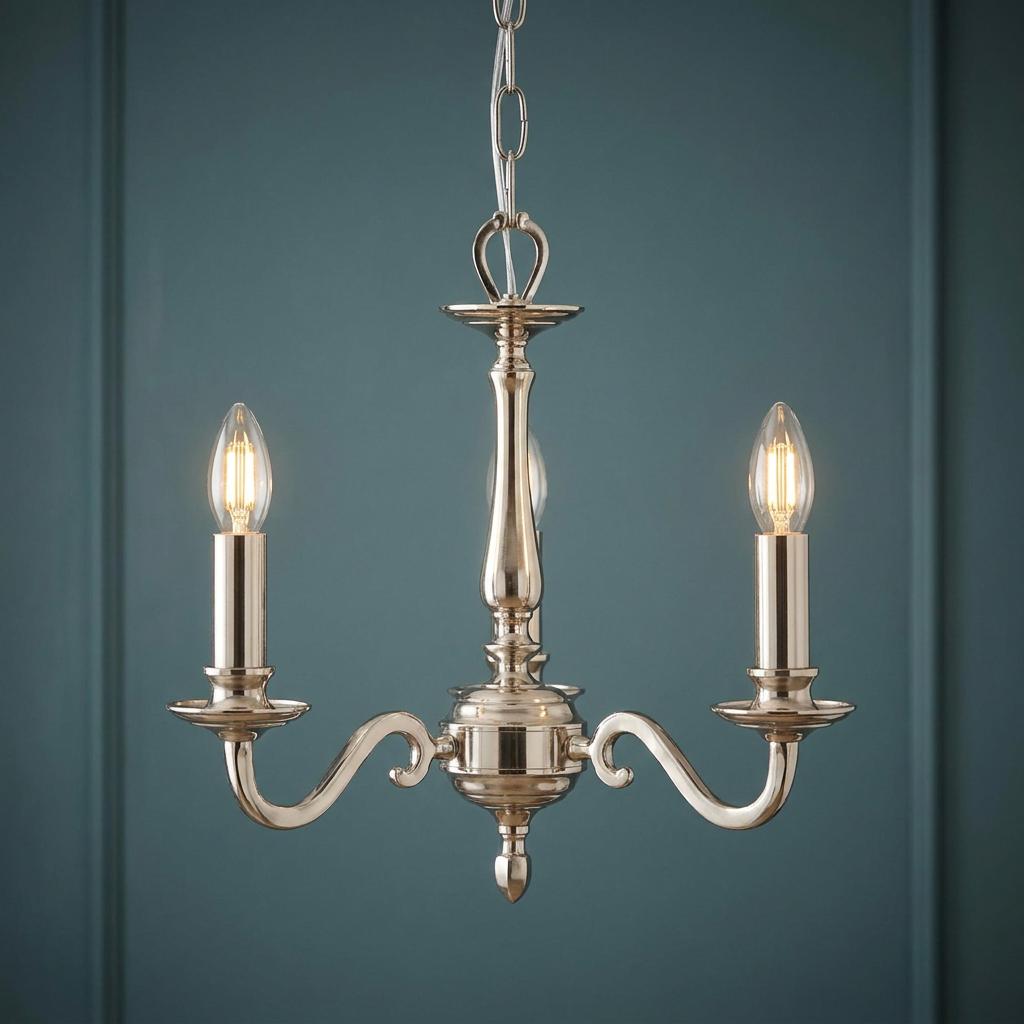 A three-light nickel chandelier with lit candle bulbs hangs against a dark teal paneled wall.