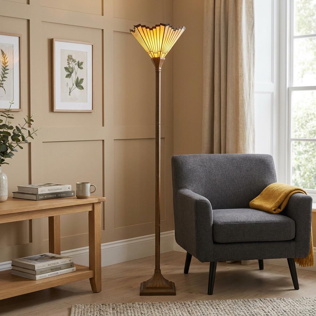 A Tiffany-style uplighter floor lamp with a fanned geometric shade in a warm, cozy living room setting.