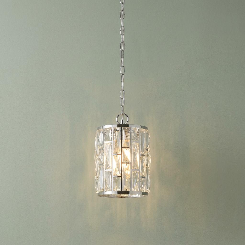 Bijou 1 light chrome pendant with a cylindrical crystal glass shade hanging from a chain against a pale wall.