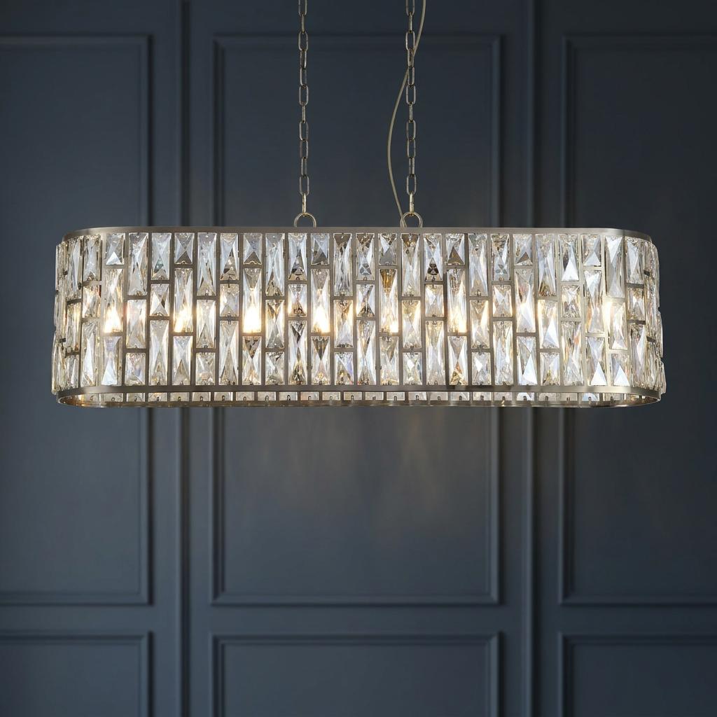 Bijou antique brass oval pendant light with glass crystal tiles illuminated against a dark blue paneled wall.