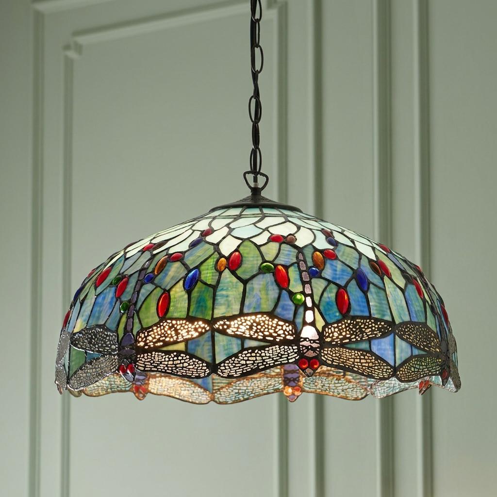 Blue dragonfly Tiffany stained glass pendant light with colorful beads, hanging from a chain in a paneled room.