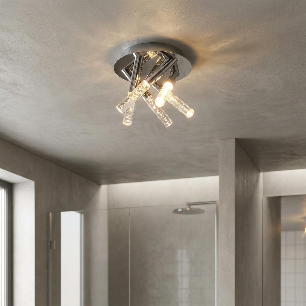 Modern five-light chrome flush ceiling fixture with bubble glass cylinders mounted in a grey bathroom.
