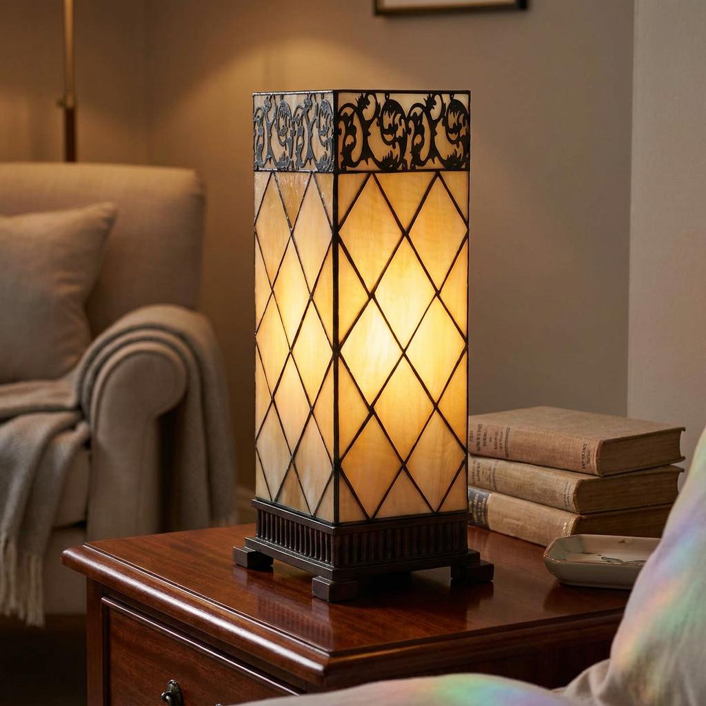 Square Tiffany table lamp with diamond-patterned cream glass and ornate black trim on a wooden side table.