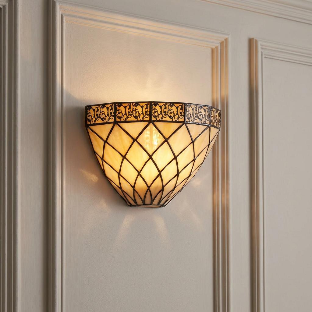 Art Deco-style Tiffany wall light with a warm-glowing lattice pattern and decorative filigree on a paneled wall.