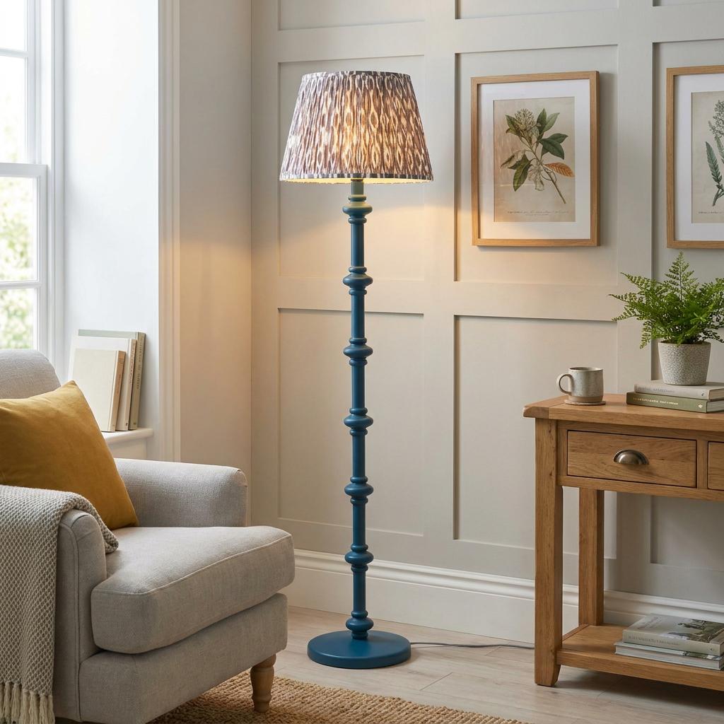 Blue wooden spindle floor lamp with an ikat pattern shade in a cozy living room corner next to an armchair.