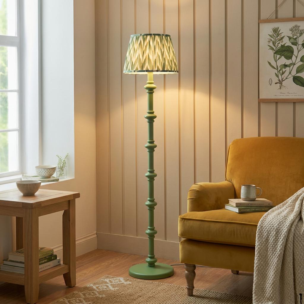 Green bobbin floor lamp with a zigzag shade stands beside a yellow armchair in a cozy, sunlit living room.