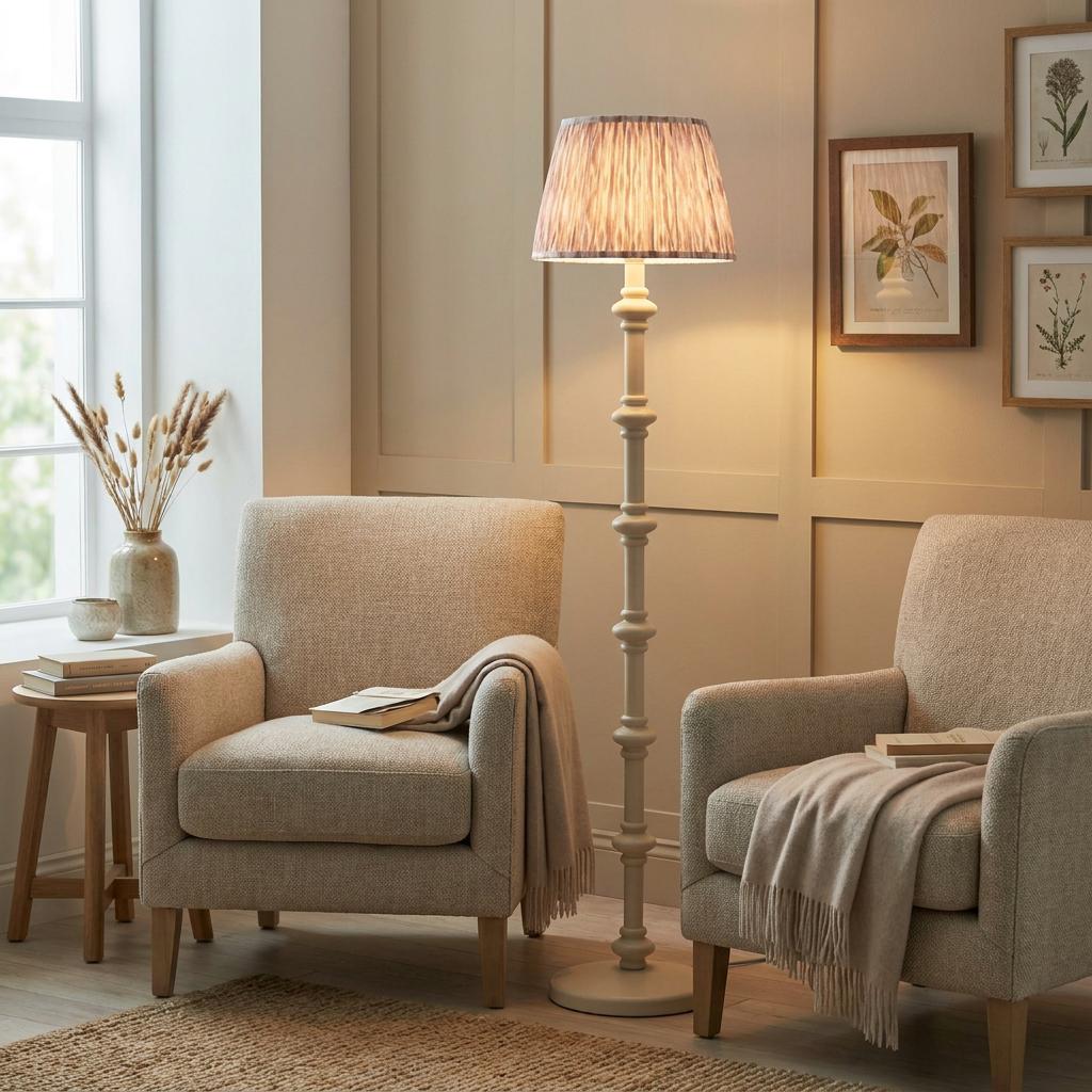 White floor lamp with ikat shade between two beige armchairs in a warm living room setting.