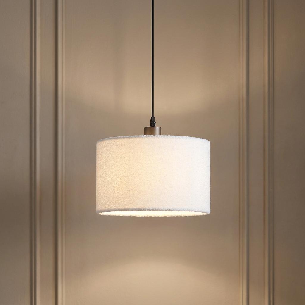 A Chelsea pendant light with a white synthetic cashmere shade glowing against a paneled wall.