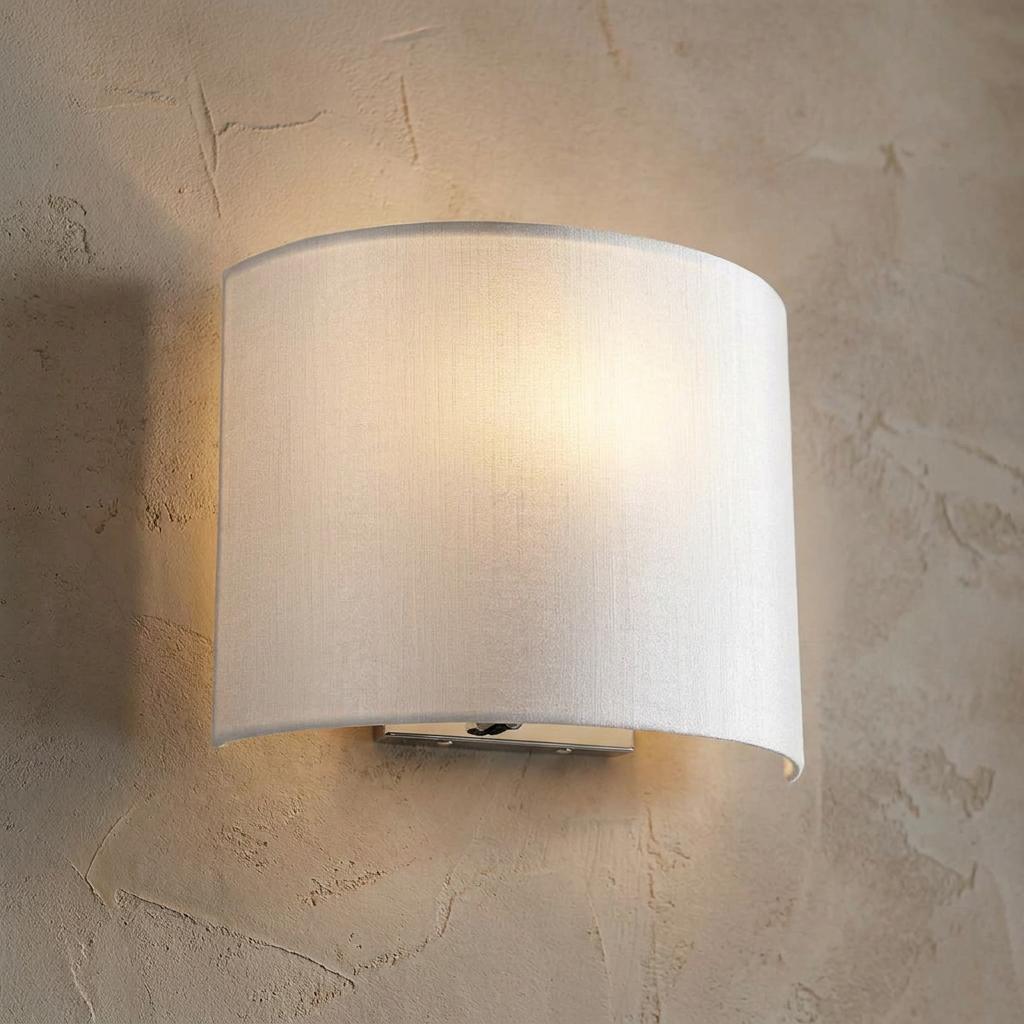 Curved white fabric wall light illuminated against a textured beige plaster wall.