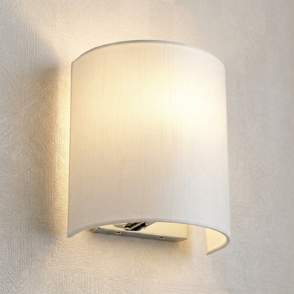 Cooper curved wall light with a white fabric shade and polished chrome base, glowing on a neutral textured wall.