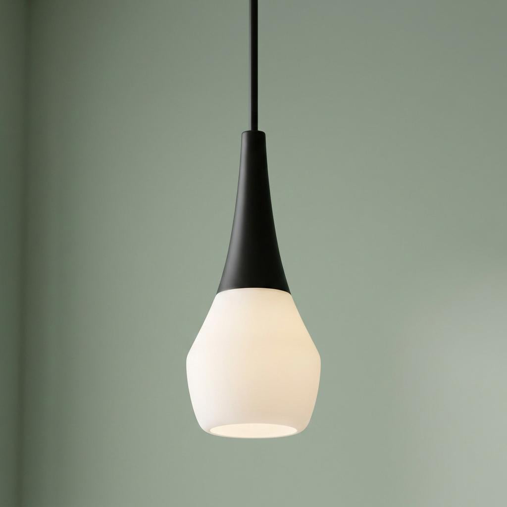 Deela black ceiling pendant light featuring a white opal glass shade and sleek black top against a green wall.