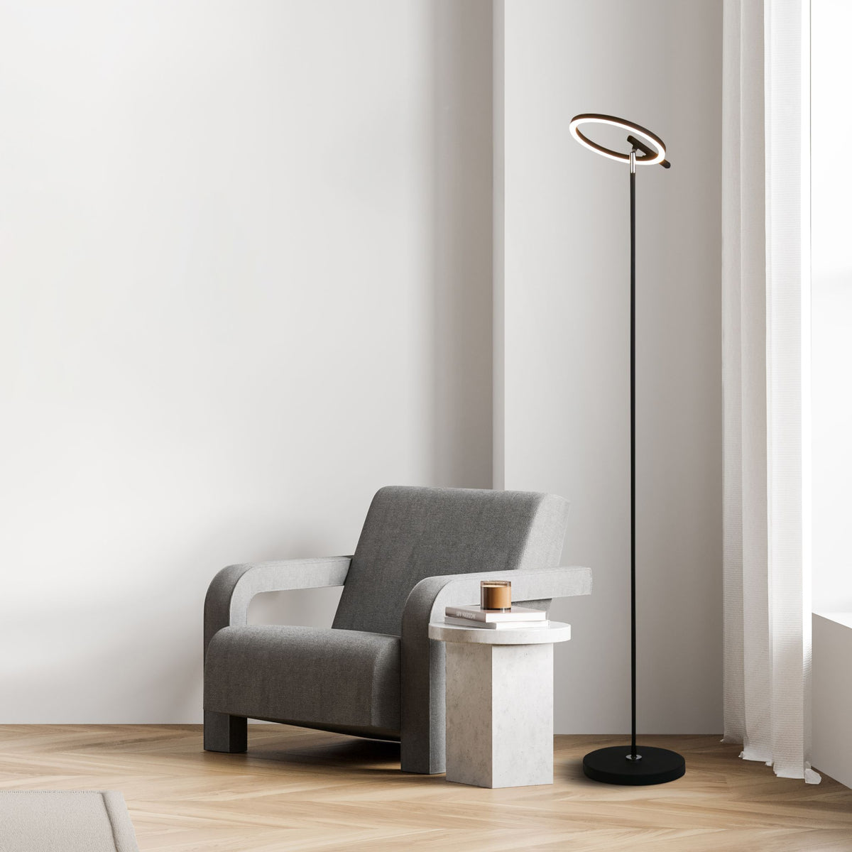 Space floor lamp beside a grey armchair and concrete side table by a curtained window