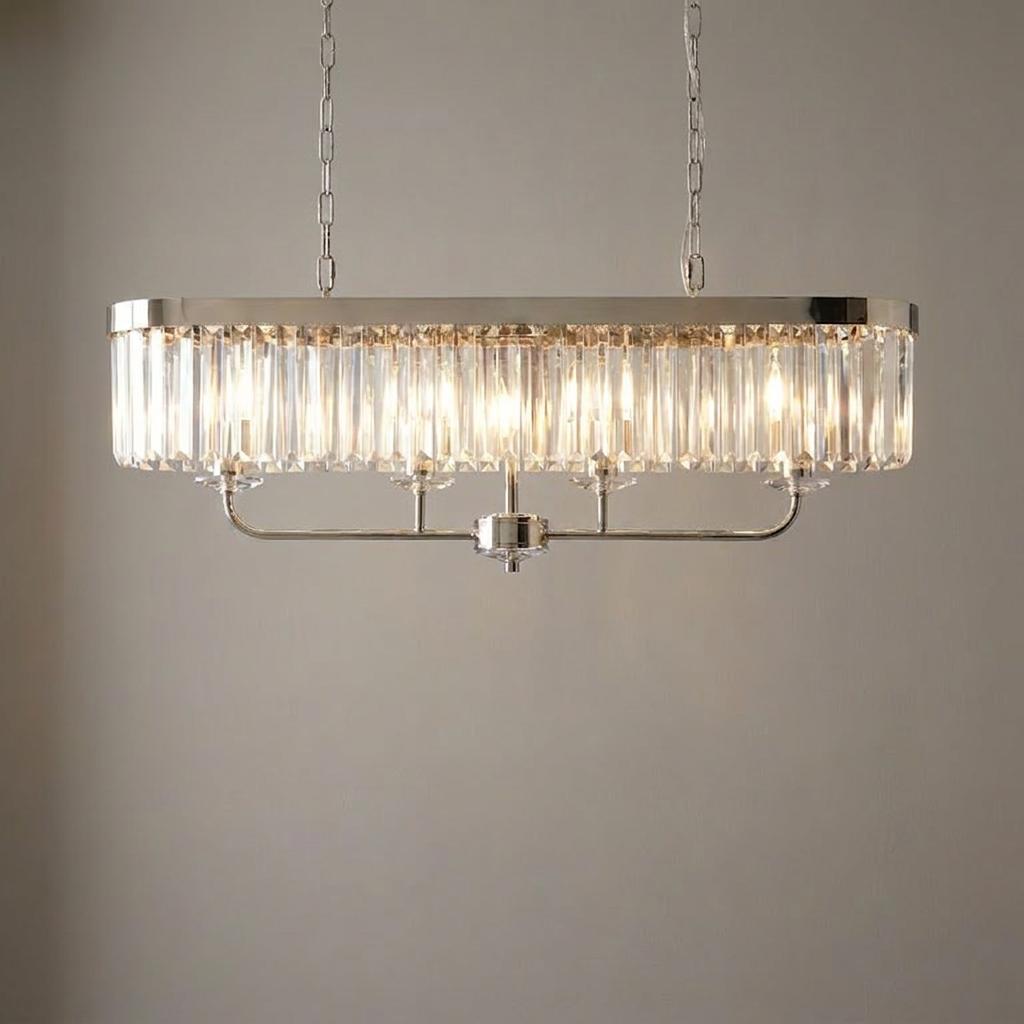 Polished nickel 4-light linear ceiling pendant with vertical cut faceted glass prisms against a plain neutral wall.