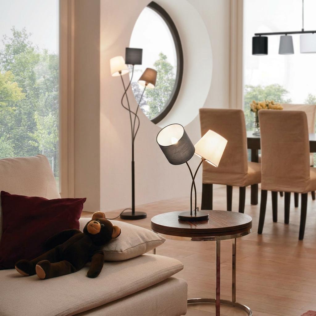 Eglo Almeida 2-light table lamp with black and white fabric shades on a wooden side table in a bright living room.