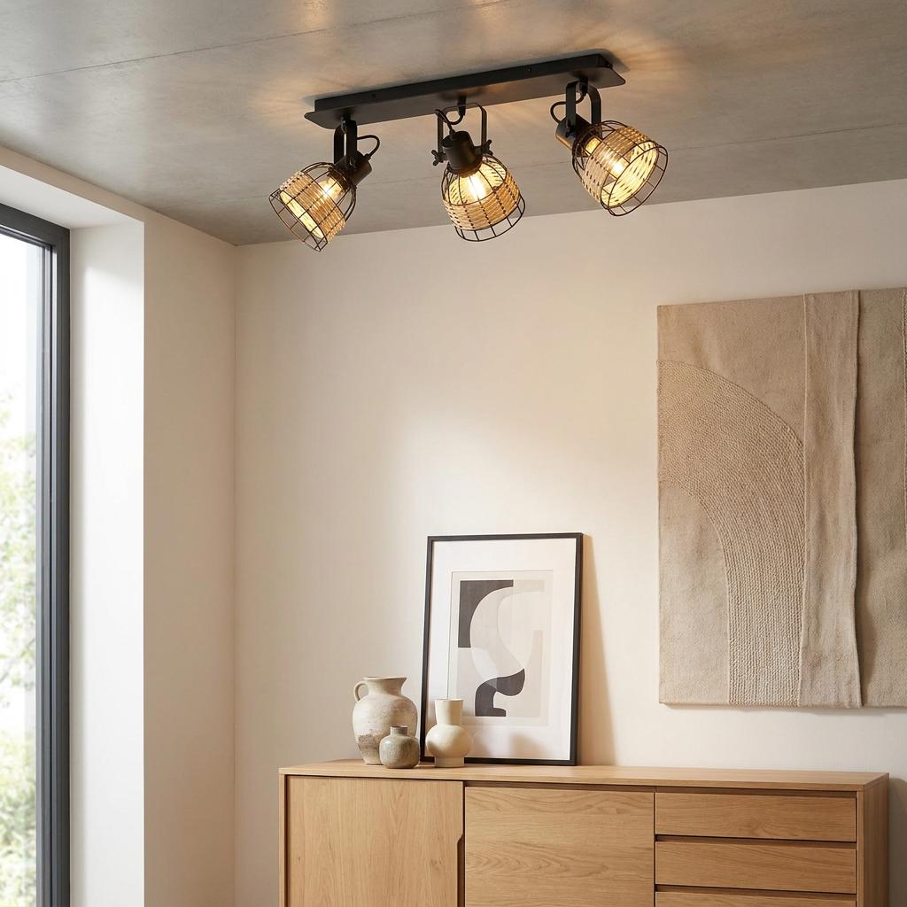 A three-light ceiling spotlight with black frames and rattan cage shades mounted on a grey concrete-style ceiling.