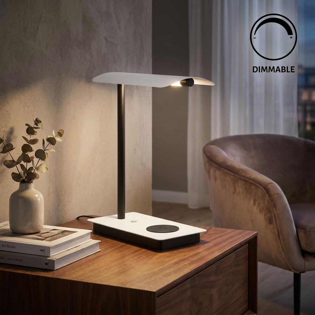 Modern black and white LED table lamp with a curved shade on a wooden desk in a warm living room setting.