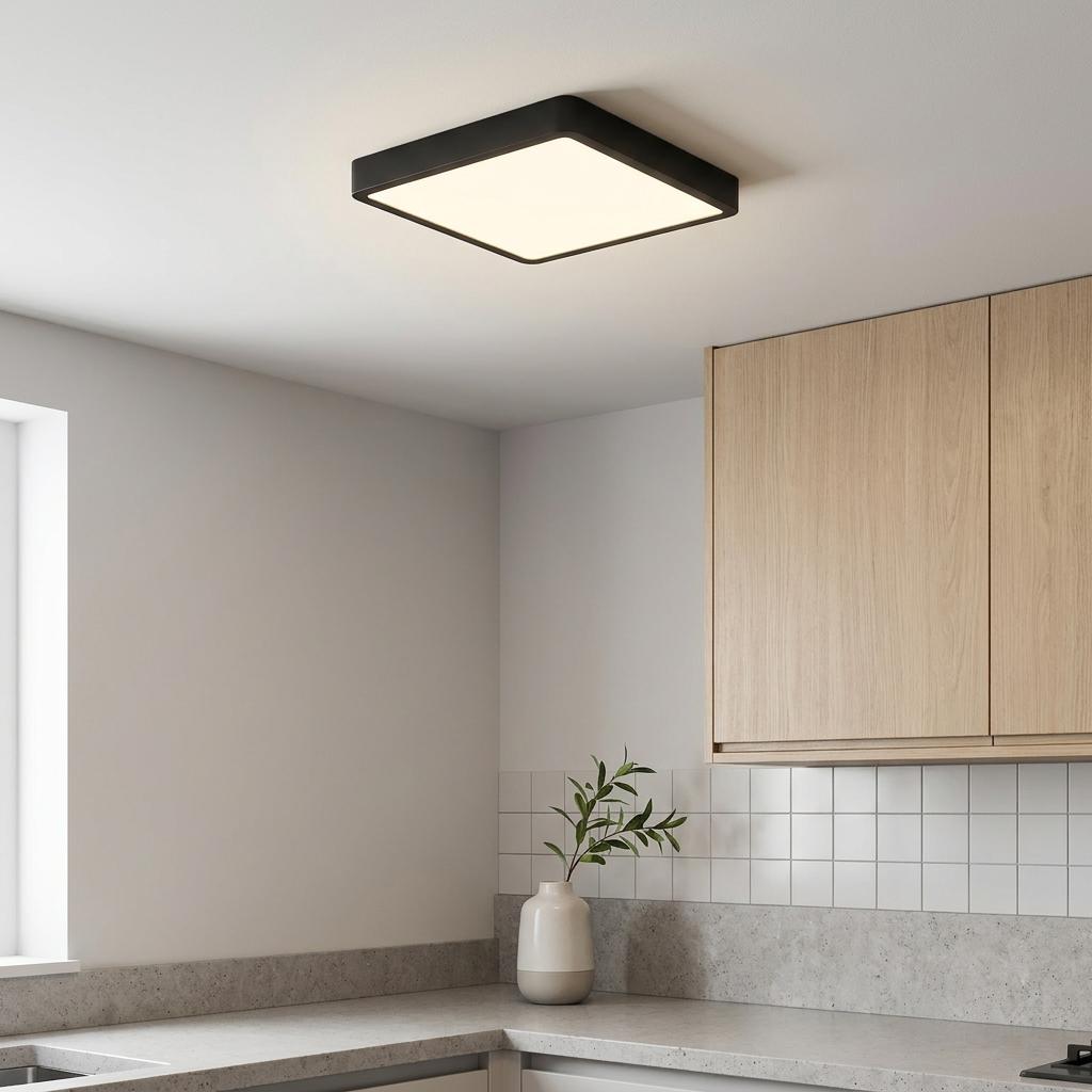 Square black LED flush ceiling light illuminating a modern kitchen above a grey countertop.