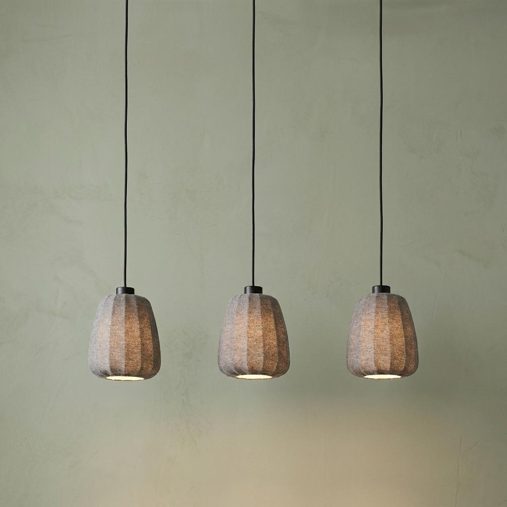 Three grey pleated fabric pendant lights hanging against a pale green wall.