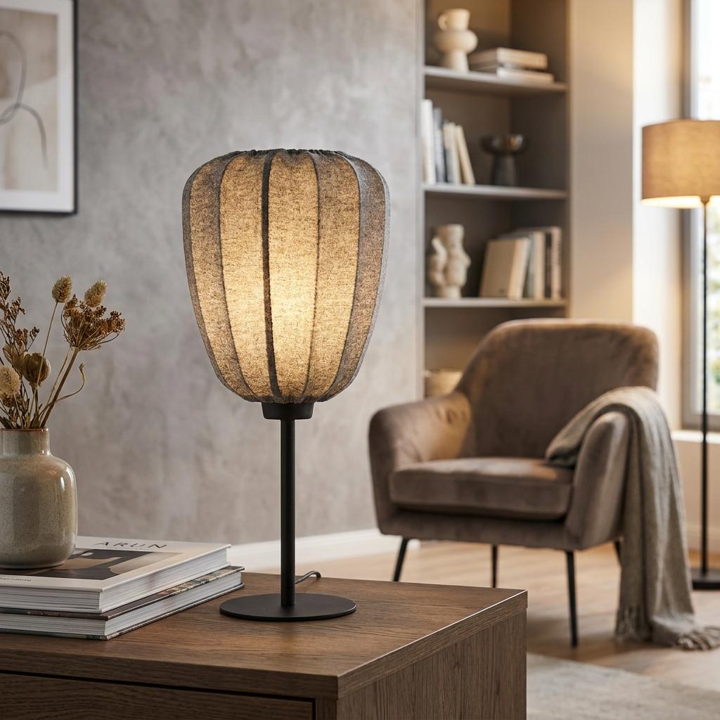 Eglo Barlaston table lamp with a grey ribbed fabric shade and black metal base on a wooden table in a living room.