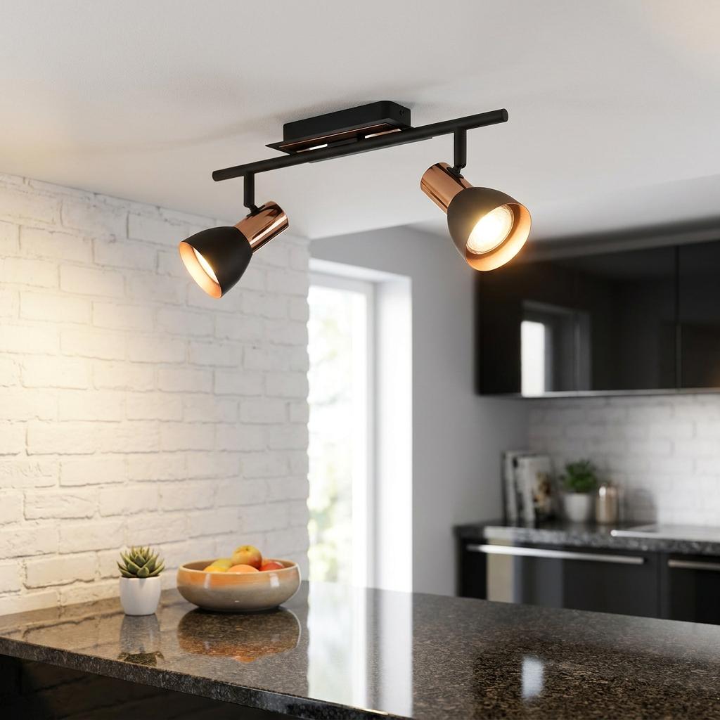 Eglo Barnham 2-light copper and black bar spotlight illuminating a modern kitchen above a granite countertop.