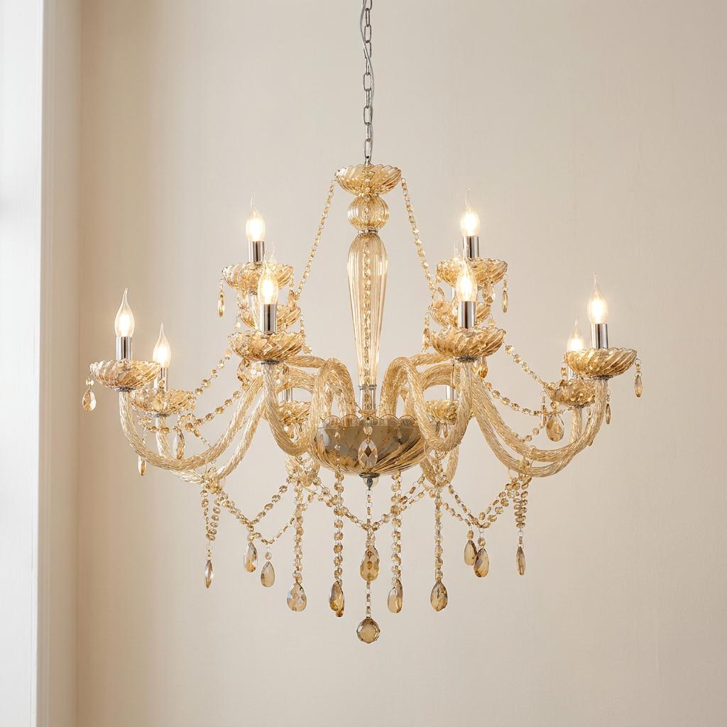 Twelve-light chandelier featuring cognac glass arms and hanging crystal droplets against a neutral wall.