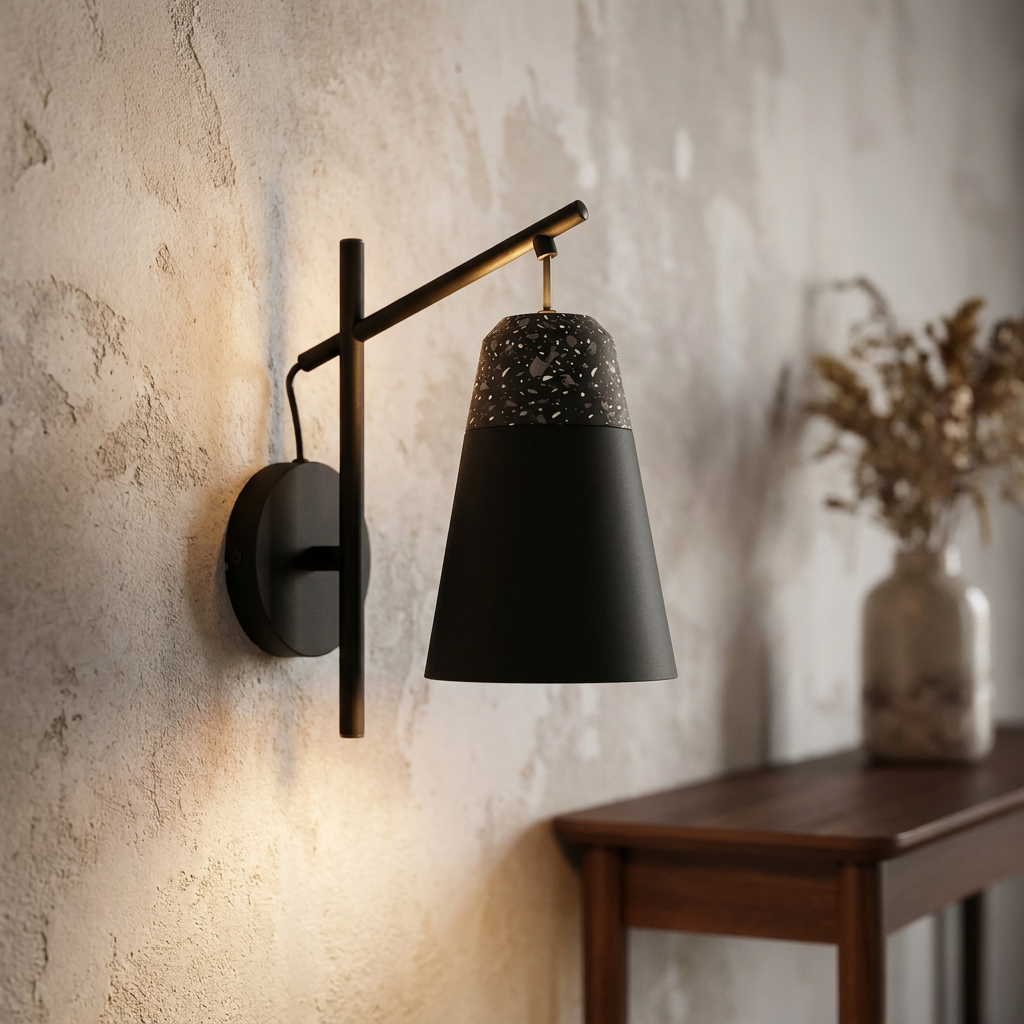 Black Eglo Canterras wall light with a terrazzo-patterned conical shade on a textured plaster wall.