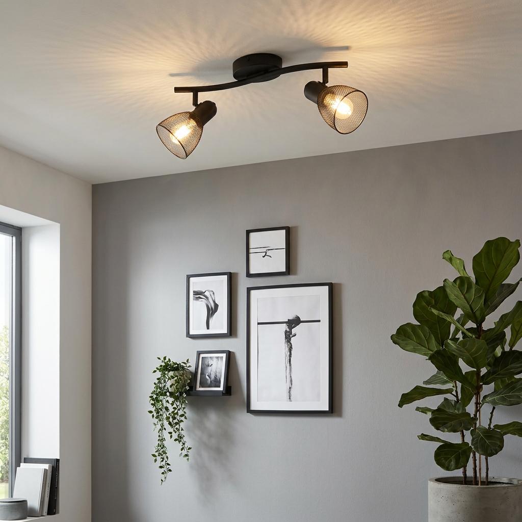 Eglo Carovigno black mesh 2-light bar spotlight casting patterned light over a gallery wall in a modern room.