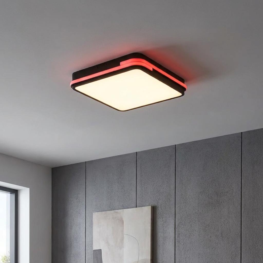 Square black smart LED ceiling light with a white panel and red accent glow in a modern interior.