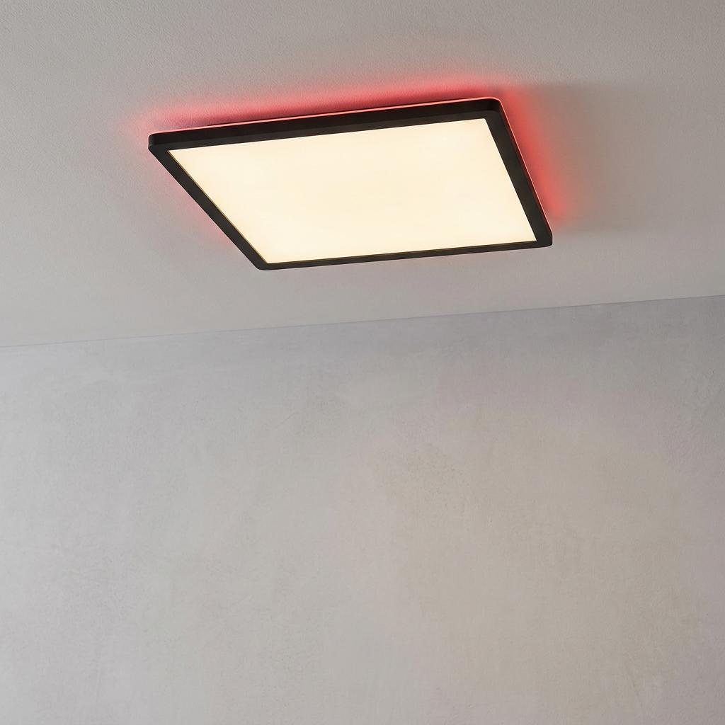 Square black LED ceiling light with a warm white panel and a decorative red backlight glow against a neutral wall.