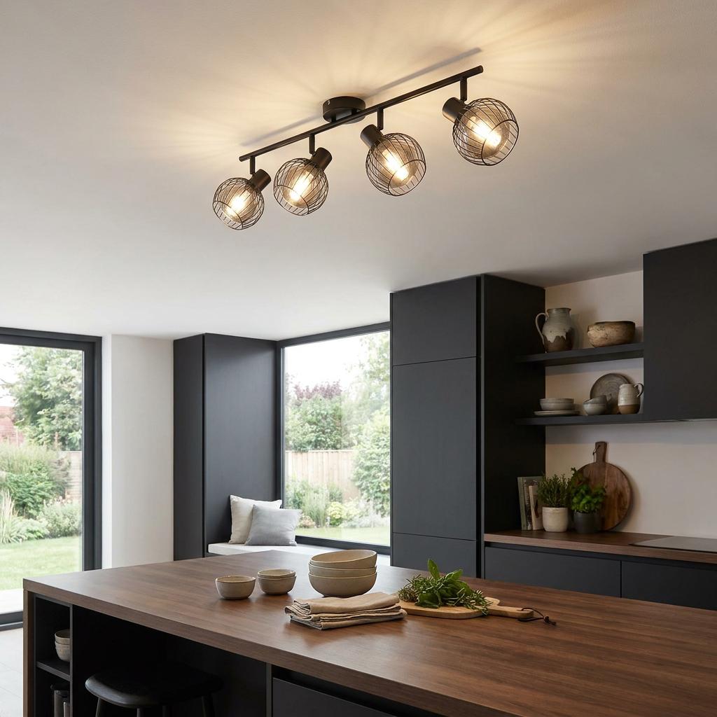 Eglo Consaca black wire 4-light bar spotlight on a kitchen ceiling above a wooden island and dark cabinets.