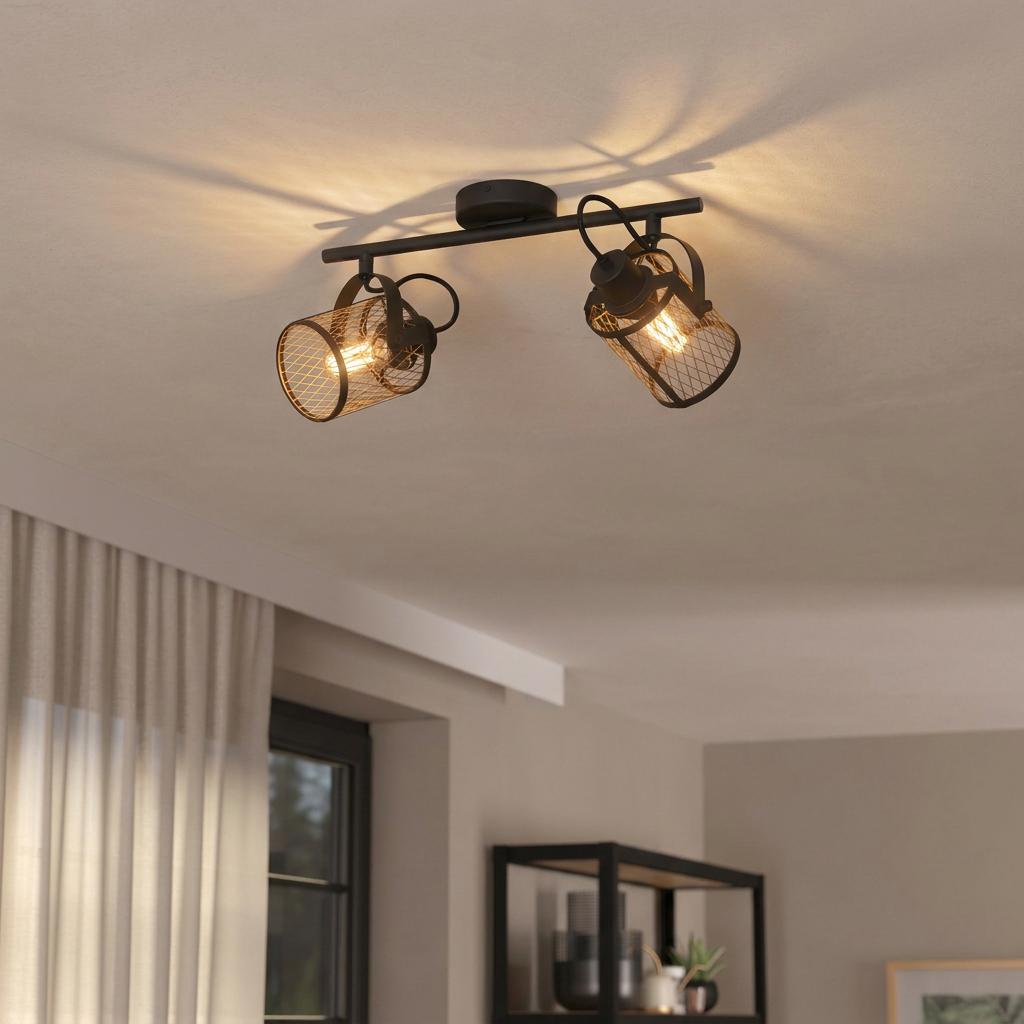 Eglo Dellow 2-light bar spotlight with black frame and brass mesh shades glowing on a ceiling.