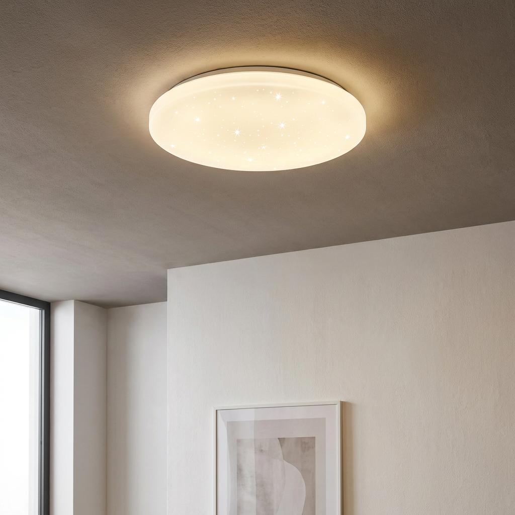 Eglo Frania-A round white LED flush ceiling light with a starry effect glowing on a grey ceiling.