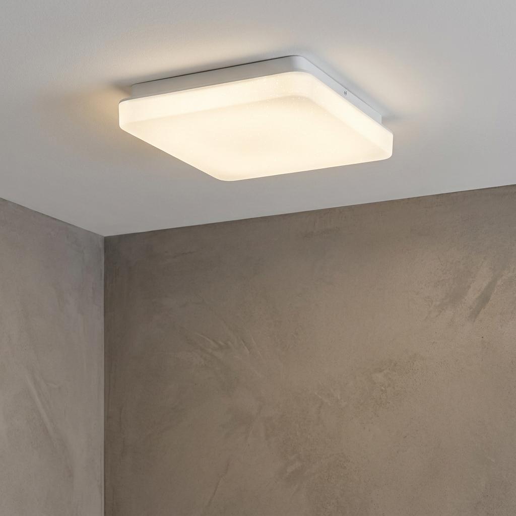 Square white flush LED ceiling light glowing in a modern room with textured walls.
