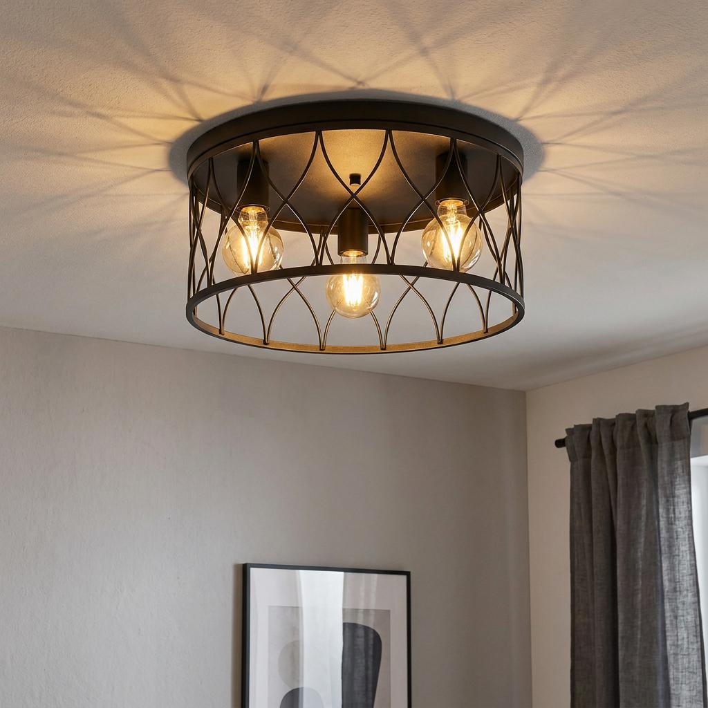 Black metal drum ceiling light with a geometric lattice pattern casting decorative shadows in a room.