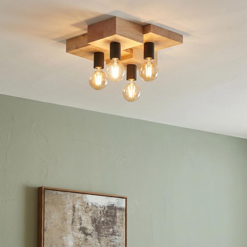 Modern flush-mount ceiling light with a geometric wooden base and four clear globe bulbs in a sage green room.