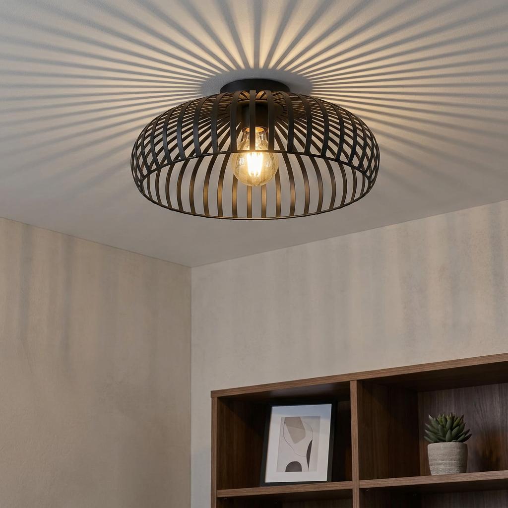 Black caged flush ceiling light casting radial shadows on a white ceiling in a modern interior setting.