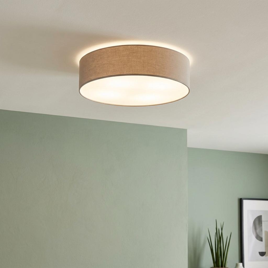 Taupe fabric drum flush ceiling light with a white diffuser, lit against sage green walls.