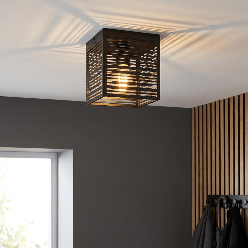 Square black metal slatted flush ceiling light casting striped patterns on the ceiling in a modern room.