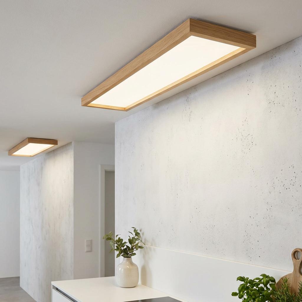 Rectangular oak-framed LED panel flush light illuminating a modern white-walled interior.