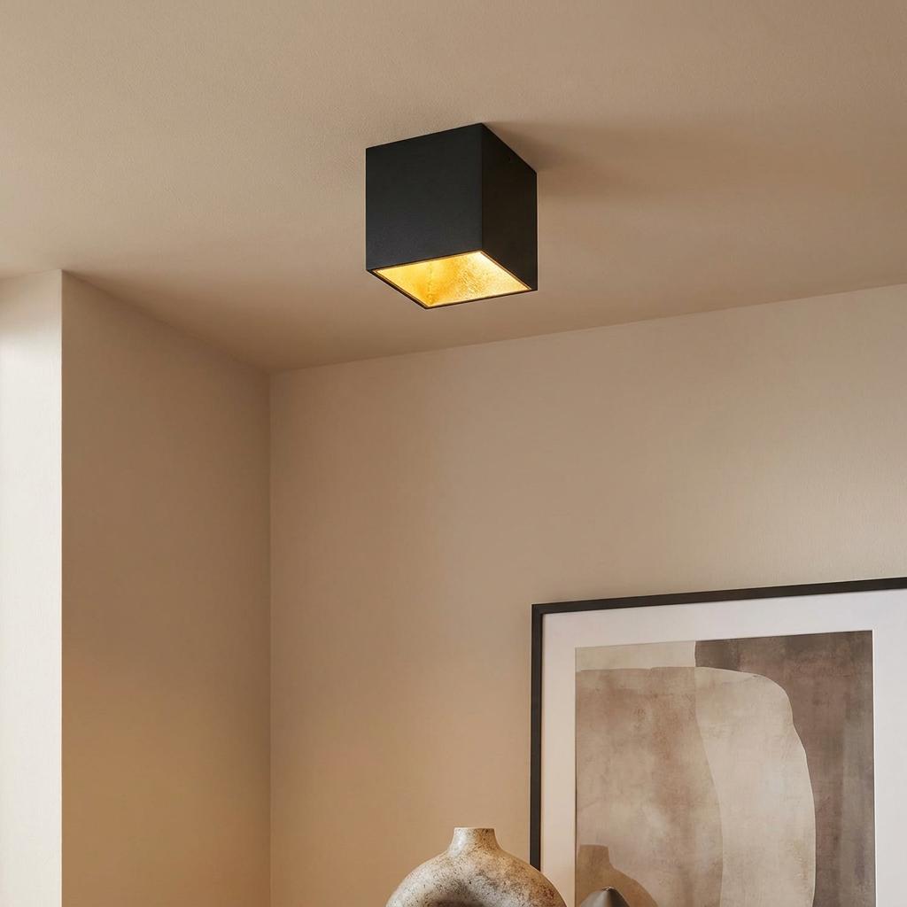 Modern black square flush ceiling light with a gold interior mounted in a neutral room.