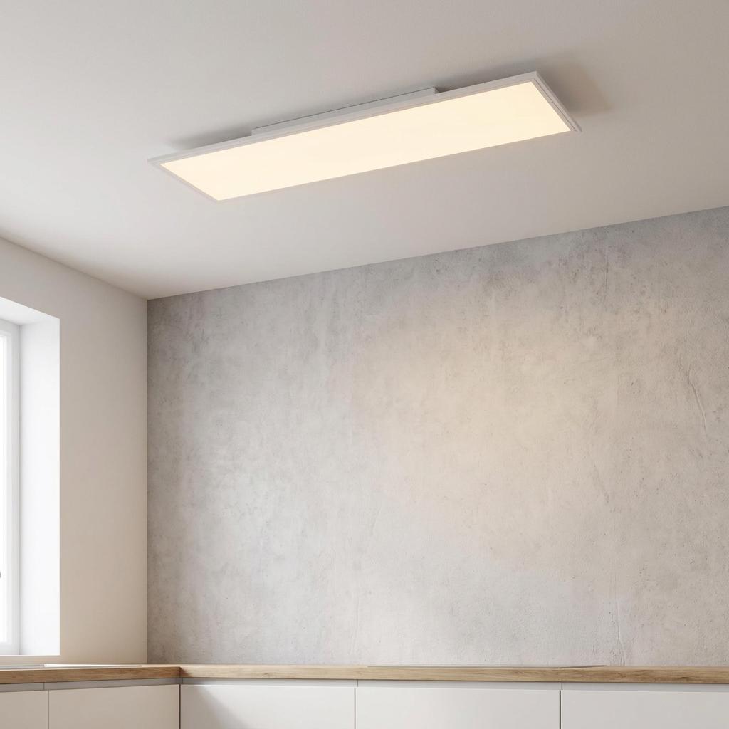 Rectangular LED flush ceiling light illuminating a minimalist room with a grey concrete-style wall.