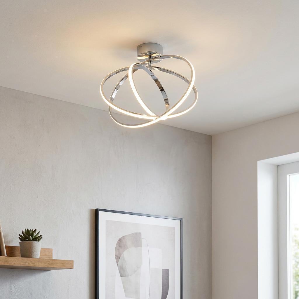 Modern Eglo Selvina chrome ceiling light with three interlocking glowing LED rings mounted in a minimalist room.