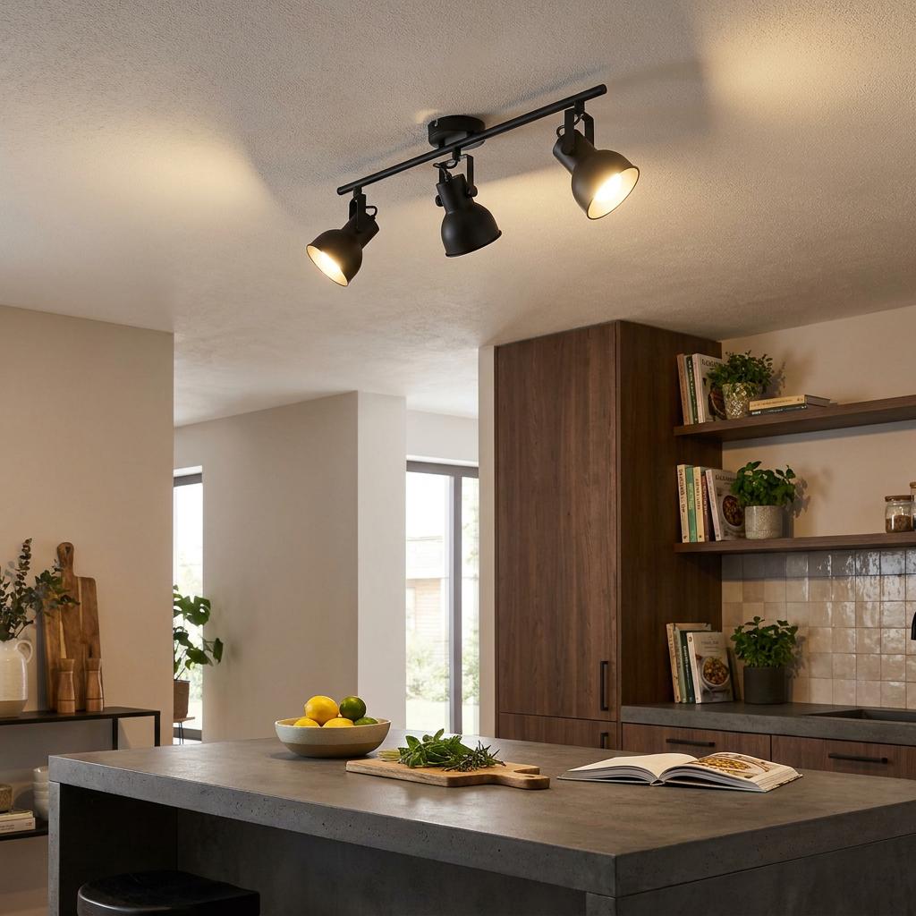 Eglo Seras 2 black 3-light bar spotlight mounted on a ceiling, illuminating a modern kitchen island and wooden cabinets.