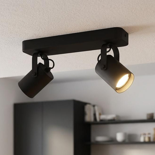 Eglo Sorego black 2-light bar spotlight mounted on a kitchen ceiling, illuminating a wooden countertop.