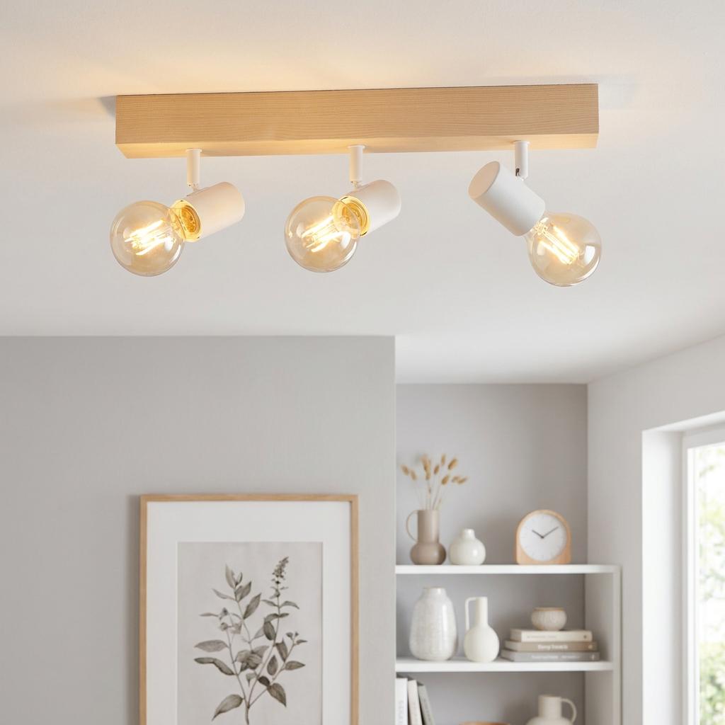 Eglo Townshend 3 spotlight with white sockets and filament bulbs on a light wood beam mounted to a white ceiling.