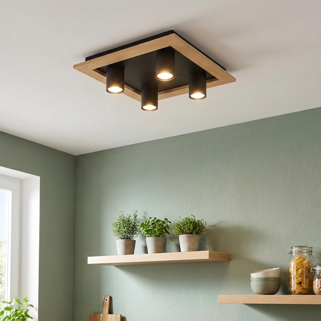 Square black and wood ceiling light with four spotlights illuminating a modern kitchen with sage green walls.