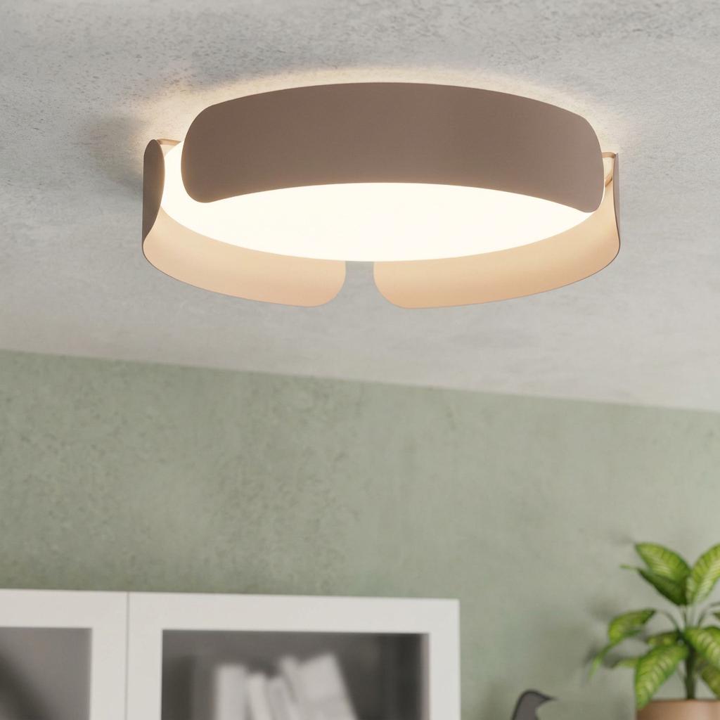 Modern mocha-framed round ceiling flush light with a layered band design glowing against a grey ceiling.